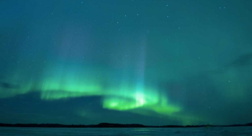 The northern lights appear in hues of green and blue